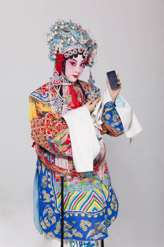东方人,一个人,演员,站,打电话,竖图,室内,白天,正面,民族服装,化妆,电话,手机,亚洲,仅一个年轻女性,仅一个女性,仅一个人,表演,握,灰色背景,服装,装饰,头饰,拿,拿着,注视,黄种人,文化,通讯设备,扮演,衣服,彩妆,发饰,饰品,观察,看,站着,握着,摄影,服饰,影棚,观看,华丽,修饰,点缀,察看,演出,衣着,穿着,关注,中国文化,摄影棚,戏剧,表演服,演出服,智能手机,京剧,配饰,戏曲,国粹,一部,皮黄,衬托,美观,雅致,雅观,衣饰,道具服,青衣,交流,年轻女性,女人,女性,亚洲人,沟通,通话,站立,半身,彩图,影棚拍摄,传统服装,民俗服,拍摄,京剧服饰,国剧,京戏,平剧,中国戏曲,旦角,传统文化,舞台妆,旦,京剧演员,角色,正旦