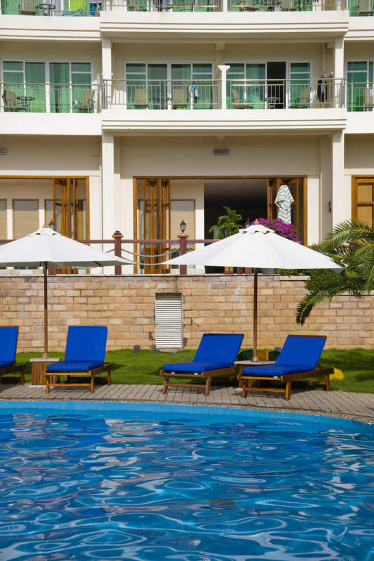 无人,游泳池,宾馆,露台,竖图,室外,白天,正面,旅游,度假,水,植物,阳台,标志建筑,地标,建筑,酒店,椅子,三亚,中国,亚洲,阴影,波纹,光线,伞,影子,雨伞,遮阳伞,躺椅,水池,水面,两把,四把,娱乐,阳伞,建设,泳池,树,树木,海南,蓝色,绿色,白色,倒影,水纹,阳光,自然,波浪,享受,休闲,旅游胜地,放松,海南省,生长,成长,酒家,沙滩椅,旅社,倒映,太阳伞,东亚,三亚湾,三亚市,中华人民共和国,华南地区,琼,反照,彩图,客店,客栈,露天阳台,旅店,旅馆,三亚湾度假区,商旅,三亚亚太国际会议中心,亚太国际会议中心