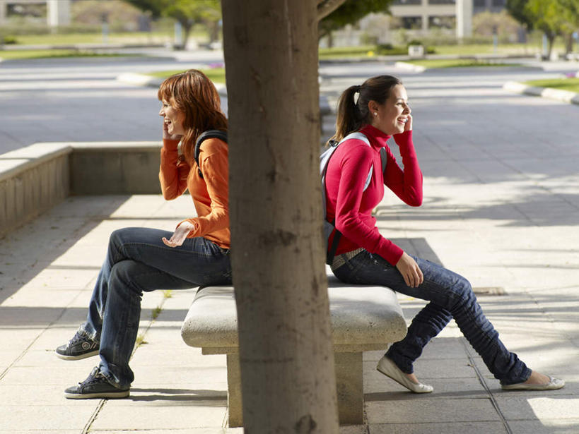 西方人,两个人,坐,笑,打电话,微笑,露齿笑,横图,室外,白天,侧面,安全,草地,草坪,植物,道路,路,公路,电话,手机,欧洲,欧洲人,握,阴影,服装,裤子,光线,影子,凳子,石凳,棕色,交通,二郎腿,拿,拿着,依靠,注视,牛仔裤,休闲装,通讯设备,草,树,树木,衣服,绿色,阳光,自然,观察,看,倚靠,背靠背,休闲,休闲服,背对背,握着,服饰,生长,成长,观看,察看,关注,交流,信任,年轻女性,女人,女性,白种人,长发,马路,沟通,通话,坐着,彩图,全身