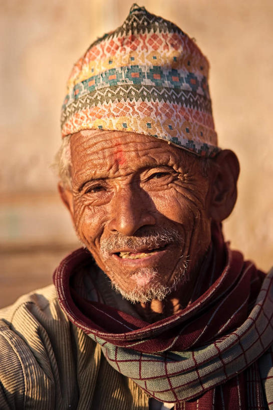 东方人,脸,头,脸颊,皱纹,胡须,一个人,坐,笑,微笑,露齿笑,竖图,室外,特写,白天,正面,帽子,亚洲,仅一个男性,仅一个人,阴影,服装,朦胧,模糊,装饰,光线,影子,墙,注视,休闲装,黄种人,墙壁,墙面,老人,衣服,阳光,围巾,观察,看,仅一个老年男性,休闲,温暖,休闲服,服饰,围脖,观看,保暖,华丽,点缀,察看,御寒,关注,无边帽,衬托,美观,雅致,雅观,白叟,老年男性,男人,男性,亚洲人,头部,胡子,小胡子,脸部,脸蛋,面部,坐着,半身,彩图