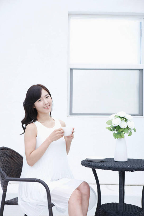 东方人,一个人,坐,笑,微笑,露齿笑,竖图,室内,白天,正面,裙子,窗户,桌子,杯子,花瓶,椅子,亚洲,仅一个年轻女性,仅一个女性,仅一个人,握,连衣裙,盛开,木制,瓷器,陶瓷,墙,咖啡杯,陶瓷制品,拿,花蕾,茶几,拿着,注视,黄种人,玻璃窗,墙壁,墙面,花,花瓣,花朵,鲜花,白色,木制品,瓶子,花苞,花蕊,观察,看,握着,观看,察看,关注,瓷杯,年轻女性,女人,女性,亚洲人,坐着,半身,彩图
