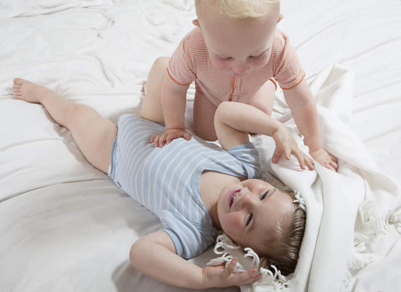 西方人,婴儿,儿童,两个人,家庭,躺,跪,笑,微笑,露齿笑,横图,俯视,室内,白天,婴儿服装,纯洁,床,靠垫,卧室,纺织品,欧洲,欧洲人,服装,装饰,毛毯,毯子,双人床,床单,靠枕,光脚,被子,裸露,纺织,小孩,衣服,垫子,枕头,低头,趴着,温暖,温馨,一家人,赤脚,可爱,服饰,活泼,华丽,修饰,点缀,和睦,被单,衣着,穿着,宝宝,裸,纯真,烂漫,无邪,衬托,美观,雅致,雅观,卧着,伶俐,天真,白种人,孩子,跪着,趴,躺着,卧,半身,彩图,高角度拍摄,婴儿服,睡房,卧房,融洽