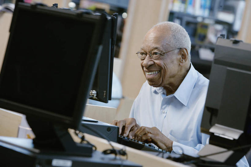 西方人,一个人,坐,笑,微笑,露齿笑,横图,室内,白天,正面,衬衫,电脑,显示器,鼠标,键盘,欧洲,非洲,黑人,欧洲人,仅一个男性,仅一个人,朦胧,模糊,网络,输入设备,通讯设备,仅一个老年男性,台式电脑,书橱,查询,通信设备,输出设备,老年男性,男人,男性,非洲人,坐着,半身,彩图,衬衣