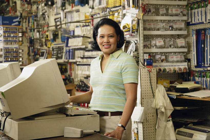 东方人,一个人,店员,商店,站,笑,微笑,露齿笑,横图,室内,白天,正面,电脑,显示器,鼠标,键盘,亚洲,仅一个女性,仅一个人,服装,网络,注视,休闲装,黄种人,输入设备,通讯设备,商铺,货架,架子,衣服,观察,看,站着,仅一个中年女性,营业员,休闲,休闲服,台式电脑,pos机,服饰,收银台,观看,察看,关注,收银,收银机,通信设备,陈列架,输出设备,超市货架,市肆,商号,销售人员,女人,女性,中年女性,亚洲人,售货员,站立,半身,彩图,店铺,五金店