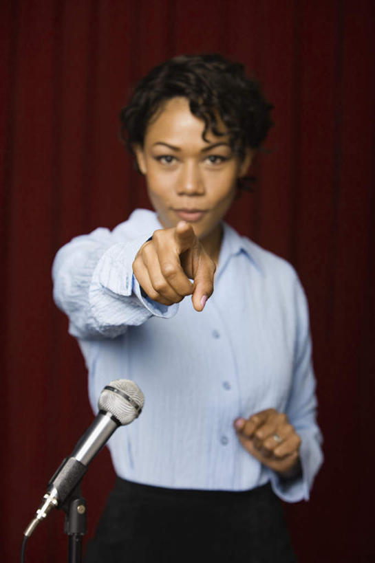 西方人,一个人,商务人士,商务女性,站,竖图,室内,白天,正面,欧洲,非洲,黑人,欧洲人,仅一个年轻女性,仅一个女性,仅一个人,指,套装,注视,方向,话筒,讲台,观察,看,手势,站着,帷幕,观看,察看,麦克风,指向,食指,关注,扩音器,帷幔,演说台,商务装,幕布,幕帘,传声器,工薪阶层,演讲台,微音器,帷幔布,年轻女性,女人,女性,非洲人,白领,上班族,站立,半身,彩图