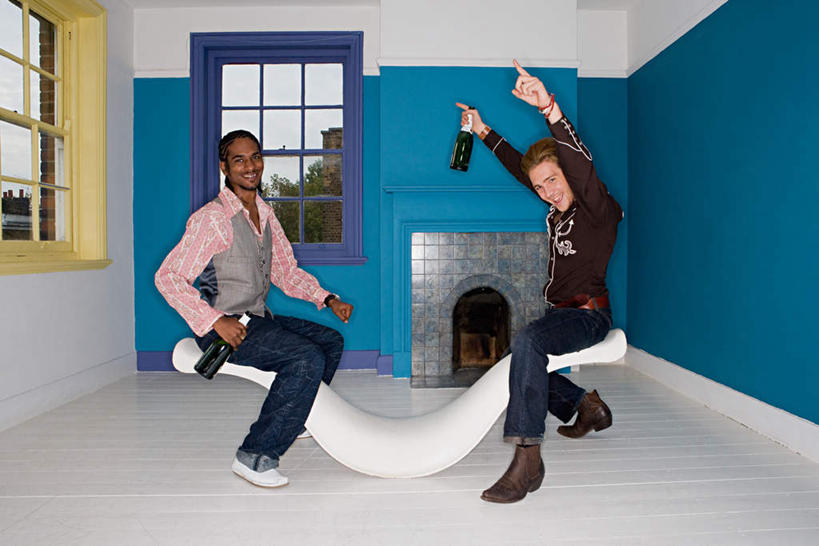 西方人,两个人,伙伴,朋友,客厅,坐,举,笑,微笑,露齿笑,横图,室内,白天,侧面,鞋,游戏,友谊,壁炉,窗户,玩具,鞋子,欧洲,非洲,黑人,欧洲人,握,服装,裤子,墙,皮革,拿,玩,拿着,扭头,注视,牛仔裤,休闲装,娱乐,玻璃窗,墙壁,墙面,玻璃制品,酒瓶,两个,衣服,蓝色,白色,玻璃瓶,瓶子,观察,看,托,转头,休闲,休闲服,翘翘板,益智,握着,服饰,观看,活动,察看,起居室,发泄,关注,消遣,智力,宣泄,客堂,友情,年轻女性,女人,女性,白种人,非洲人,举起,举手,举着,玩耍,嬉戏,向上举,向上伸,向上托,坐着,彩图,全身,皮鞋