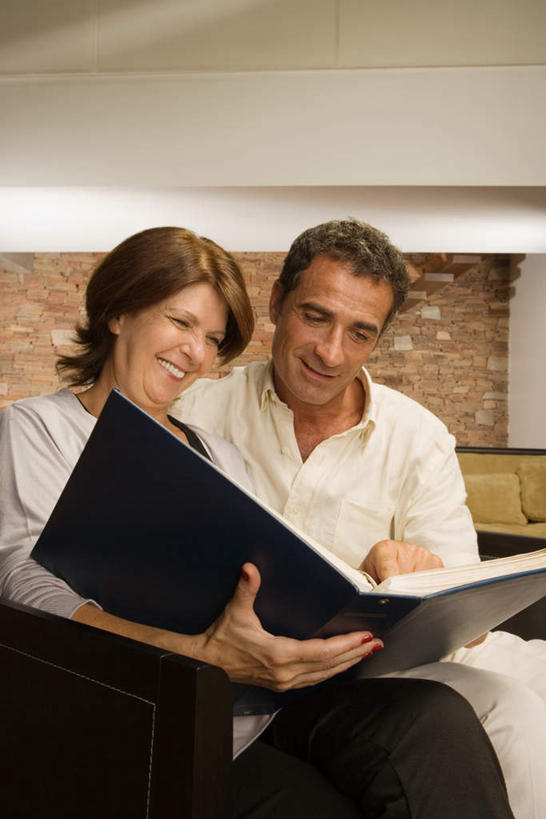 西方人,老年人,两个人,家庭,夫妻,客厅,坐,笑,微笑,露齿笑,竖图,照片,室内,白天,正面,爱情,沙发,欧洲,欧洲人,握,相册,墙,浪漫,拿,拿着,注视,墙壁,墙面,观察,看,温暖,温馨,一家人,恩爱,握着,恋人,摄影,观看,和睦,察看,起居室,关注,布艺沙发,客堂,老年男性,老年女性,男人,男性,女人,女性,白种人,夫妇,情侣,相片,坐着,半身,彩图,拍摄,照相,伴侣,融洽