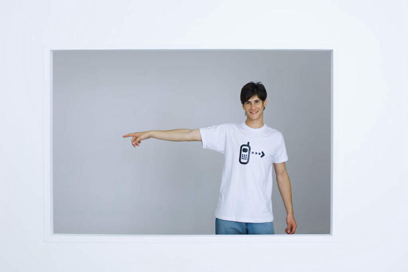 西方人,一个人,站,笑,打电话,微笑,露齿笑,横图,室内,白天,白色背景,正面,T恤衫,快乐,电话,手机,欧洲,欧洲人,仅一个男性,仅一个人,指,标志,图案,字符,T恤,注视,通讯设备,标识,仅一个年轻男性,灰色,观察,看,站着,摄影,影棚,观看,察看,指着,关注,交流,男人,男性,年轻男性,白种人,沟通,通话,站立,半身,彩图,影棚拍摄,高兴,愉快,拍摄