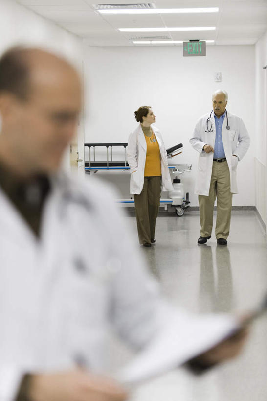 西方人,三个人,医生,医院,站,说,竖图,室内,白天,侧面,讨论,指示牌,照明,欧洲,欧洲人,朦胧,模糊,标志,材料,档案,文件,文字,墙,走廊,灯光,注视,标识,顶灯,相视,墙壁,墙面,灯,资料,灯具,观察,看,站着,医护人员,医疗人员,面对面,观看,对视,照亮,察看,白大褂,照明设备,关注,文档,相对,急救床,医疗机构,相看,交流,老年男性,男人,男性,年轻女性,女人,女性,白种人,大夫,沟通,讲话,交谈,商讨,说话,谈话,站立,半身,彩图,病院,诊所