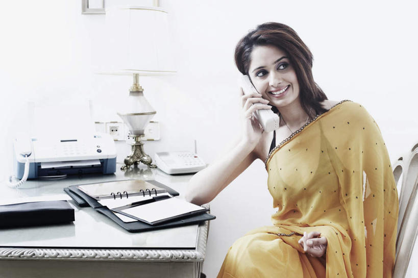 一个人,办公室,坐,笑,打电话,微笑,露齿笑,横图,室内,白天,正面,民族服装,通讯,职员,家具,台灯,桌子,电话,椅子,照明,亚洲,仅一个年轻女性,仅一个女性,仅一个人,撑,握,传输,笔,办公桌,灯光,办公用品,记事本,拿,拿着,注视,通讯设备,灯,文具,本子,笔记本,话筒,学习用品,灯具,观察,看,电话线,握着,通信,服饰,观看,飘逸,传真机,办公设备,文具用品,照亮,传真,察看,撑着,庄重,照明设备,关注,追求,输出设备,纱丽,办公家具,雅致,纱丽服,清婉,妍丽,交流,年轻女性,女人,女性,亚洲人,印度人,白领,商人,上班族,电话机,沟通,通话,坐着,半身,彩图,传统服装,民俗服,白领阶层,办公室职员,奢华