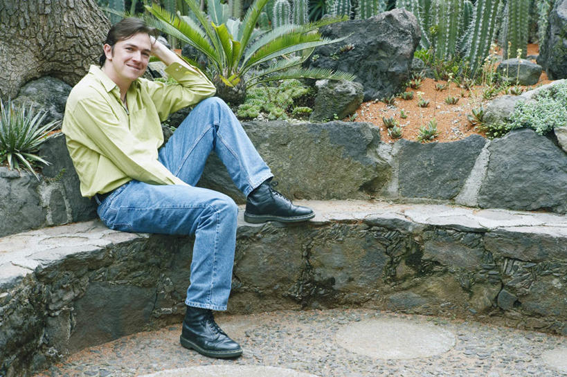 西方人,一个人,坐,笑,微笑,横图,室外,白天,侧面,石头,植物,仙人掌,欧洲,欧洲人,仅一个男性,仅一个人,仅一个中年男性,撑,服装,裤子,火焰,石子,草药,托腮,注视,牛仔裤,休闲装,中药,衣服,观察,看,托,休闲,休闲服,服饰,观看,察看,关注,托下巴,药材,中草药,中药材,本草,牛舌头,男人,男性,中年男性,白种人,石块,岩石,玉芙蓉,仙巴掌,火掌,霸王树,坐着,彩图,全身