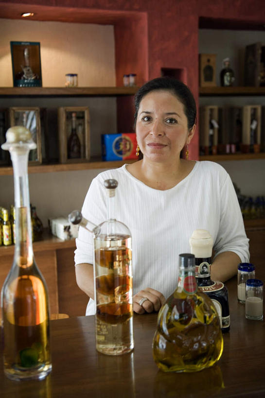 西方人,一个人,酒吧,站,笑,微笑,竖图,室内,白天,正面,欧洲,欧洲人,仅一个女性,仅一个人,许多,阴影,服装,光线,影子,灯光,伏特加,酒类,置物架,注视,文化,架子,玻璃制品,画框,酒,酒瓶,装饰品,饮料,衣服,白色,玻璃瓶,耳环,瓶子,饰品,首饰,鸡尾酒,观察,看,站着,仅一个中年女性,调酒,服饰,观看,察看,创造,衣着,穿着,关注,陈列架,想象,蒸馏酒,耳饰,特其拉日出,特其拉日出鸡尾酒,衣饰,搁架,店东,店主,东主,女人,女性,中年女性,白种人,站立,半身,彩图,酒吧间,酒馆