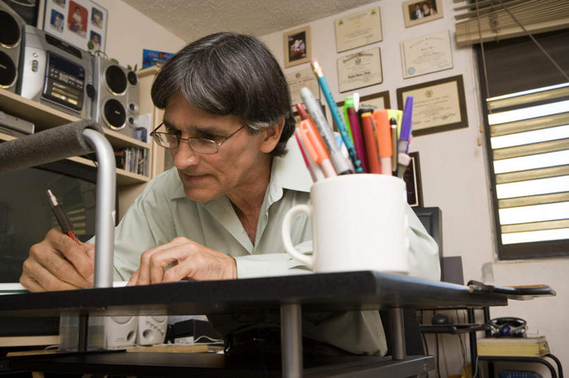 西方人,一个人,坐,横图,室外,白天,仰视,窗户,书房,桌子,杯子,电视,相框,欧洲,欧洲人,仅一个男性,仅一个人,一副,握,笔,瓷器,眼镜,百叶窗,墙,办公用品,陶瓷制品,音响,拿,拿着,注视,墙壁,墙面,文具,仅一个年轻男性,学习用品,低头,观察,看,握着,观看,文具用品,察看,关注,彩电,瓷杯,近视眼镜,彩色电视机,显像管屏,显像管屏幕,男人,男性,年轻男性,白种人,电视机,坐着,半身,彩图,低角度拍摄