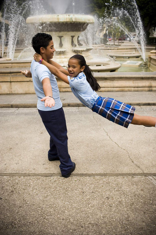 西方人,儿童,两个人,伙伴,朋友,站,抱,笑,微笑,露齿笑,竖图,室外,白天,侧面,制服,跳舞,友谊,石头,植物,喷泉,欧洲,黑人,欧洲人,阴影,服装,时间,光线,瓷砖,地砖,时钟,手表,影子,景观,地面,计时,文化,树,树木,小孩,绿色,阳光,自然,钟表,品味,站着,同学,校服,表,伸手,生长,成长,抱着,腕表,搂着,水景,舞姿,学生服,美观,友情,男孩,男人,男性,女孩,女人,女性,设计,钟,搂,搂抱,站立,半身,彩图,舞蹈,男生,女生