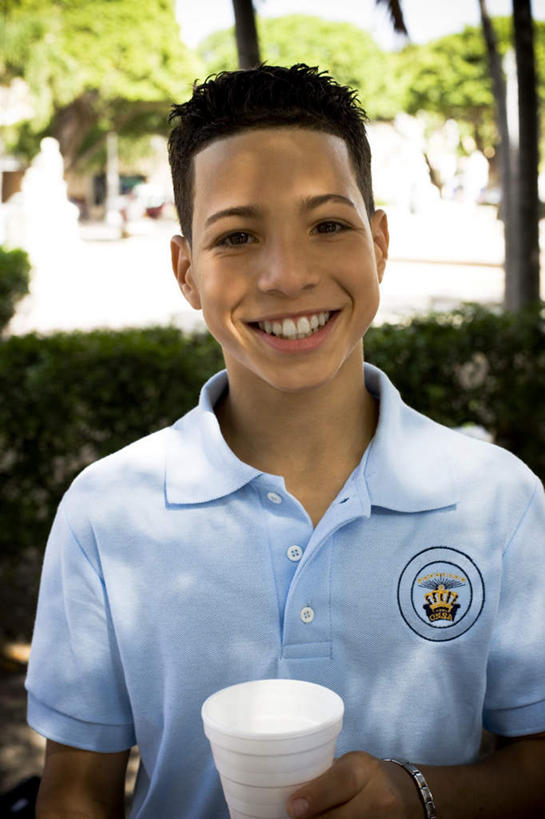 西方人,儿童,脸,头,脸颊,一个人,站,笑,微笑,露齿笑,竖图,室外,特写,白天,正面,制服,植物,杯子,欧洲,黑人,欧洲人,仅一个男性,仅一个人,握,阴影,服装,朦胧,模糊,时间,光线,时钟,手表,影子,塑料,拿,计时,拿着,注视,树,树木,小孩,绿色,阳光,自然,塑料制品,钟表,观察,看,站着,仅一个小孩,校服,表,握着,生长,成长,观看,塑料杯,腕表,察看,关注,学生服,男孩,男人,男性,孩子,头部,脸部,脸蛋,面部,钟,站立,半身,彩图,男生