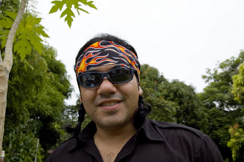 西方人,一个人,站,笑,微笑,露齿笑,横图,室外,白天,仰视,植物,欧洲,非洲,黑人,欧洲人,仅一个男性,仅一个人,一副,墨镜,眼镜,注视,树,树木,仅一个年轻男性,绿色,天空,自然,太阳镜,太阳眼镜,观察,看,站着,遮阳镜,生长,成长,观看,察看,关注,男人,男性,年轻男性,非洲人,站立,半身,彩图,低角度拍摄,头带