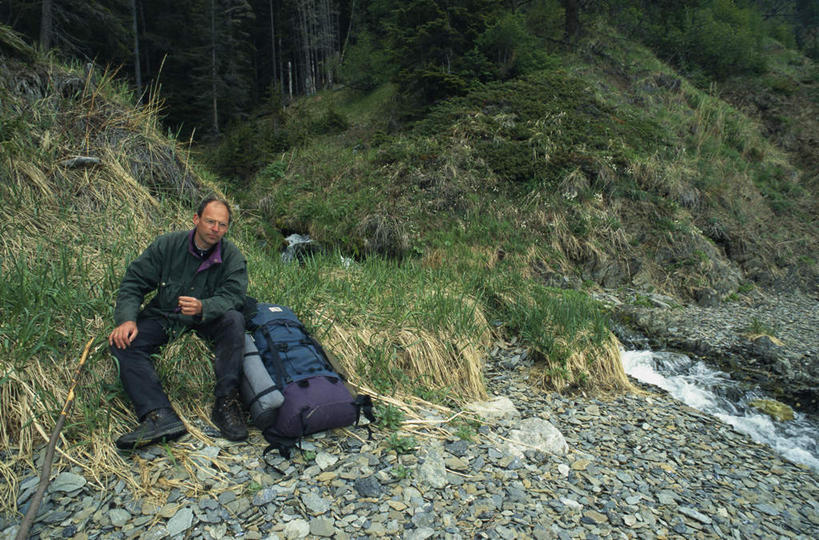 西方人,一个人,坐,横图,室外,白天,正面,草地,草坪,石头,植物,欧洲,欧洲人,仅一个男性,仅一个人,阴影,服装,光线,包,石子,影子,旅行包,注视,休闲装,草,树,树木,衣服,绿色,阳光,自然,观察,看,仅一个老年男性,休息,休闲,休闲服,服饰,生长,成长,观看,察看,关注,旅游包,提包,老年男性,男人,男性,白种人,石块,坐着,彩图,全身