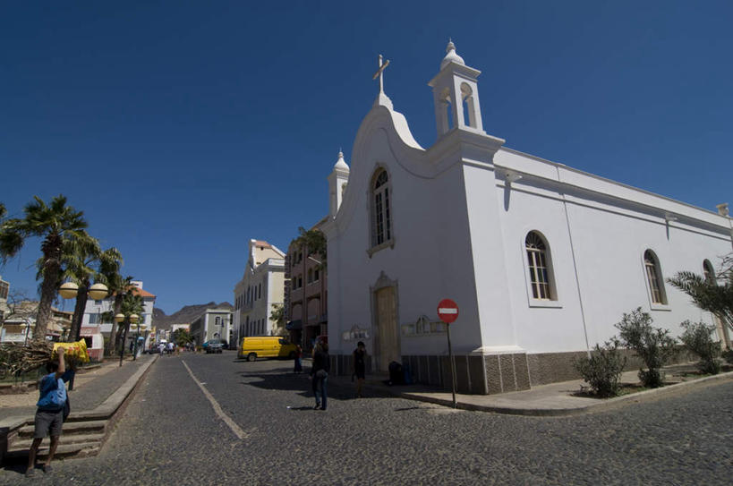 西方人,家,教堂,走,横图,室外,白天,仰视,旅游,度假,植物,标志建筑,道路,地标,建筑,路,指示牌,公路,汽车,欧洲,非洲,佛得角,黑人,欧洲人,阴影,节日,光线,标志,文字,影子,房屋,屋子,交通,许多人,文化,娱乐,标识,建设,楼房,住宅,车,树,树木,蓝色,绿色,蓝天,天空,阳光,自然,交通工具,轿车,天,祈祷,一群人,享受,休闲,健康,旅游胜地,放松,许愿,宗教,信仰,生长,成长,纪念,祈求,载具,信念,阿非利加洲,佛得角共和国,明德卢,圣维森特岛,平安,男人,男性,年轻男性,年轻女性,女人,女性,非洲人,马路,步行,散步,走路,彩图,低角度拍摄,全身,房子,大教堂,礼拜堂