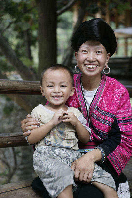 东方人,儿童,两个人,家庭,母亲,儿子,坐,抱,笑,微笑,露齿笑,竖图,室外,白天,正面,纯洁,植物,椅子,亚洲,阴影,服装,装饰,光线,影子,木椅,注视,休闲装,黄种人,少数民族,树,树木,小孩,衣服,绿色,阳光,自然,耳环,观察,看,休闲,温暖,温馨,母子,一家人,休闲服,可爱,母爱,童年,童趣,服饰,生长,成长,抱着,观看,华丽,修饰,点缀,和睦,察看,搂着,关注,童真,烂漫,无邪,瑶族,衬托,美观,雅致,雅观,耳饰,天真,男孩,年轻女性,女人,女性,亚洲人,孩子,年轻人,怀抱,搂,搂抱,相抱,拥抱,坐着,半身,彩图,融洽,男生