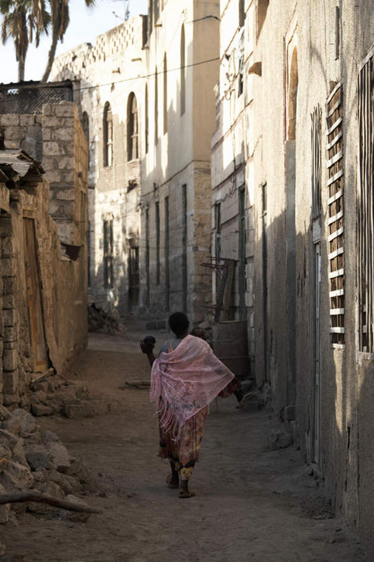 西方人,一个人,家,走,竖图,室外,白天,旅游,度假,美景,城市风光,标志建筑,城市,地标,建筑,欧洲,非洲,厄立特里亚,黑人,欧洲人,仅一个年轻女性,仅一个女性,仅一个人,阴影,服装,破旧,光线,影子,房屋,墙,屋子,景观,公寓,注视,休闲装,娱乐,建设,洋房,楼房,墙壁,墙面,住宅,背面,衣服,蓝色,蓝天,天空,阳光,天,观察,看,享受,休闲,休闲服,景色,放松,服饰,晴朗,观看,察看,关注,万里无云,阿非利加洲,厄立特里亚国,年轻女性,女人,女性,非洲人,晴空,晴空万里,步行,散步,走路,彩图,全身,房子