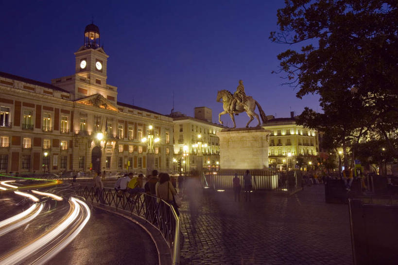 西方人,高楼大厦,栏杆,走,横图,室外,夜晚,正面,度假,美景,植物,窗户,门,城市风光,城市,大厦,道路,建筑,路,摩天大楼,公路,汽车,玻璃,雕塑,西班牙,欧洲,欧洲人,许多,行人,游客,游人,阴影,服装,艺术,装饰,时间,光线,雕刻,雕像,时钟,影子,墙,屋顶,景观,拱门,围栏,钟楼,灯光,交通,首都,很多,许多人,计时,顶棚,注视,休闲装,娱乐,护栏,路人,旅客,玻璃窗,墙壁,墙面,车,玻璃制品,树,树木,衣服,蓝色,绿色,蓝天,天空,自然,工艺品,门框,钟表,楼宇,交通工具,轿车,天,观察,看,一群人,享受,休闲,休闲服,马德里,表,景色,放松,服饰,生长,晴朗,成长,观看,纪念,美术,察看,关注,南欧,载具,主题,曝光,陈列,太阳门广场,万里无云,西班牙王国,功能,美学,塔钟,马德里自治区,过客,白种人,钟,晴空,晴空万里,马路,步行,散步,走路,彩图,全身,大楼,高层建筑,高楼,摩天楼