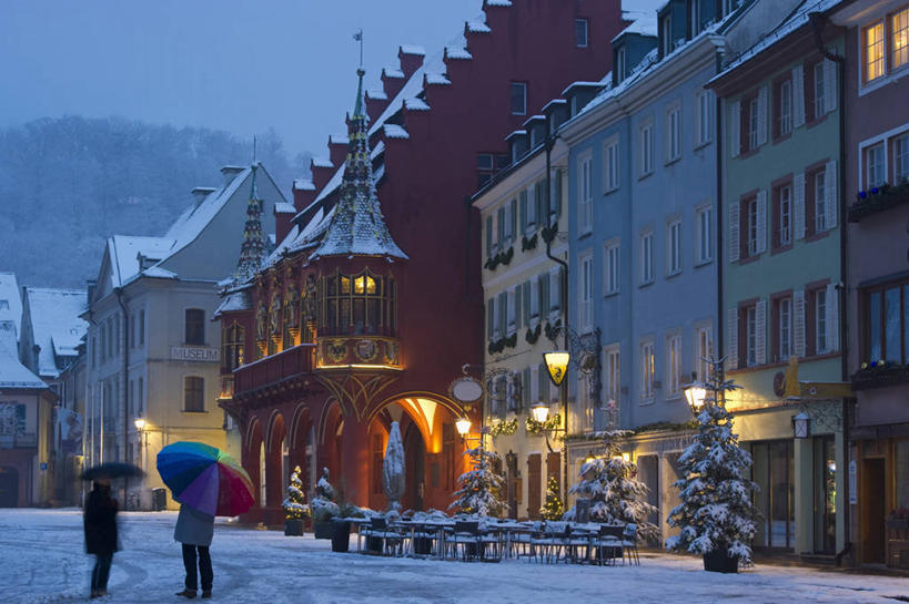 西方人,两个人,伙伴,朋友,家,站,说,横图,室外,白天,度假,讨论,友谊,美景,日落,雪,植物,大雪,城市风光,城市,路灯,椅子,照明,德国,欧洲,欧洲人,一排,服装,整齐,伞,雨伞,房屋,屋子,积雪,景观,晚霞,霞光,雪景,冬季,冬天,落日,灯光,注视,休闲装,娱乐,阳伞,楼房,住宅,灯,树,树木,排列,背面,衣服,绿色,自然,黄昏,观察,看,站着,享受,休闲,休闲服,景色,彩霞,放松,寒冷,服饰,生长,成长,观看,照亮,察看,照明设备,西欧,队列,关注,德意志联邦共和国,严寒,巴登.符腾堡,巴登.符腾堡州,巴符州,夕照,弗莱堡,弗赖堡,交流,友情,男人,男性,年轻男性,白种人,夕阳,沟通,讲话,交谈,商讨,说话,谈话,站立,彩图,全身,房子,斜阳