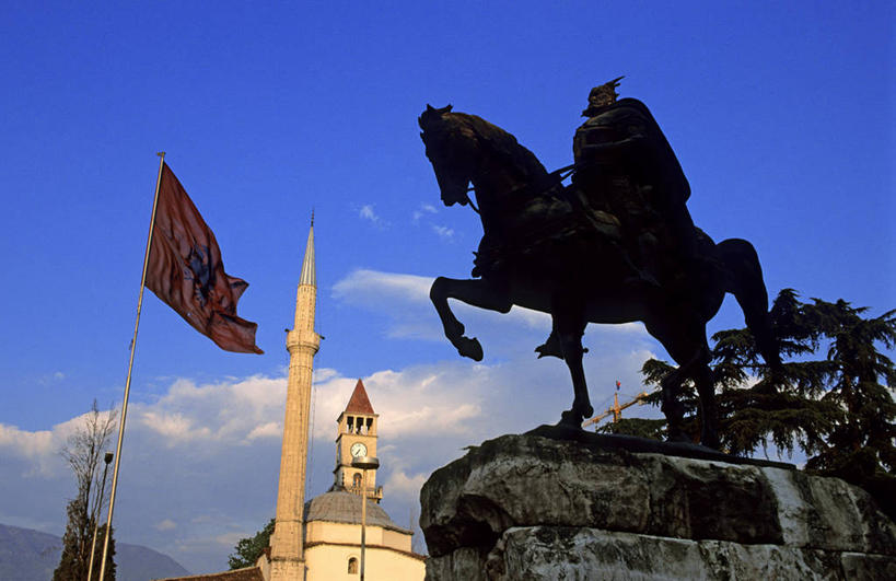 西方人,一个人,无人,坐,横图,室外,白天,仰视,旅游,度假,名胜古迹,标志建筑,地标,建筑,马,野生动物,旗帜,雕塑,欧洲,阿尔巴尼亚,欧洲人,仅一个男性,仅一个人,骑马,阴影,服装,节日,遗迹,艺术,装饰,飘扬,光线,雕刻,雕像,影子,云,云朵,首都,云彩,古迹,文化,文物,娱乐,旗子,建设,古建筑,一匹,仅一个年轻男性,骑,衣服,蓝色,白云,蓝天,天空,阳光,动物,工艺品,天,祈祷,享受,休闲,健康,旅游胜地,放松,许愿,运输,宗教,服饰,牲畜,信仰,晴朗,纪念,飘逸,祈求,美术,伊斯兰教,衣着,穿着,南欧,飞扬,主题,清真寺,陈列,古文明,功能,美学,旌旗,旗号,衣饰,阿尔巴尼亚共和国,地拉那,平安,男人,男性,年轻男性,白种人,晴空,坐着,彩图,低角度拍摄,全身