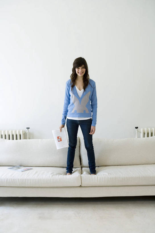 西方人,头发,一个人,站,竖图,室内,白天,正面,阅读,沙发,杂志,欧洲,欧洲人,仅一个年轻女性,仅一个女性,仅一个人,握,学习,阴影,服装,光线,影子,墙,拿,拿着,休闲装,墙壁,墙面,衣服,白色,黑色,看,站着,休闲,休闲服,读书,浏览,握着,服饰,暖气,布艺沙发,年轻女性,女人,女性,白种人,长发,站立,彩图,全身