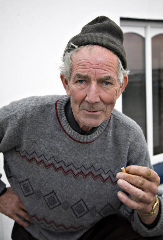 成年人,老年人,皱纹,头发,一个人,吸烟,微笑,竖图,室外,白天,毛衣,满意,香烟,爱尔兰,仅一个男性,仅一个人,休闲装,叉腰,仅一个老年男性,鸭舌帽,个性,摄影,肖像,老年男性,男人,男性,半身,彩图,好奇心,当尼戈尔郡