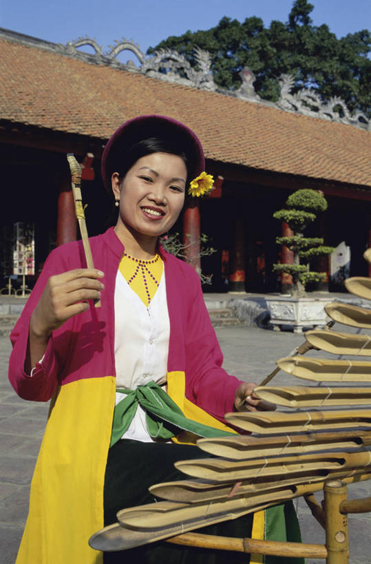 成年人,头发,一个人,笑,微笑,露齿笑,竖图,室外,白天,帽子,越南,仅一个年轻女性,仅一个女性,仅一个人,表演,屋顶,乐器,首都,音乐,拿着,花,树,黑色,摄影,肖像,河内,文庙,年轻女性,女人,女性,年轻人,彩图,传统服装,美人