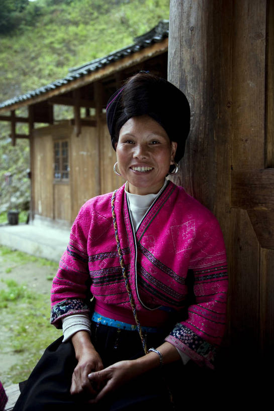 成年人,一个人,坐,握手,笑,微笑,露齿笑,竖图,室外,白天,正面,快乐,幸福,建筑,桂林,仅一个年轻女性,仅一个女性,仅一个人,木制,头饰,靠,靠着,摄影,广西,中国文化,肖像,瑶族,耳饰,年轻女性,女人,女性,亚洲人,中国人,年轻人,搀手,拉手,手拉手,手握手,彩图,传统服装,传统文化,美人