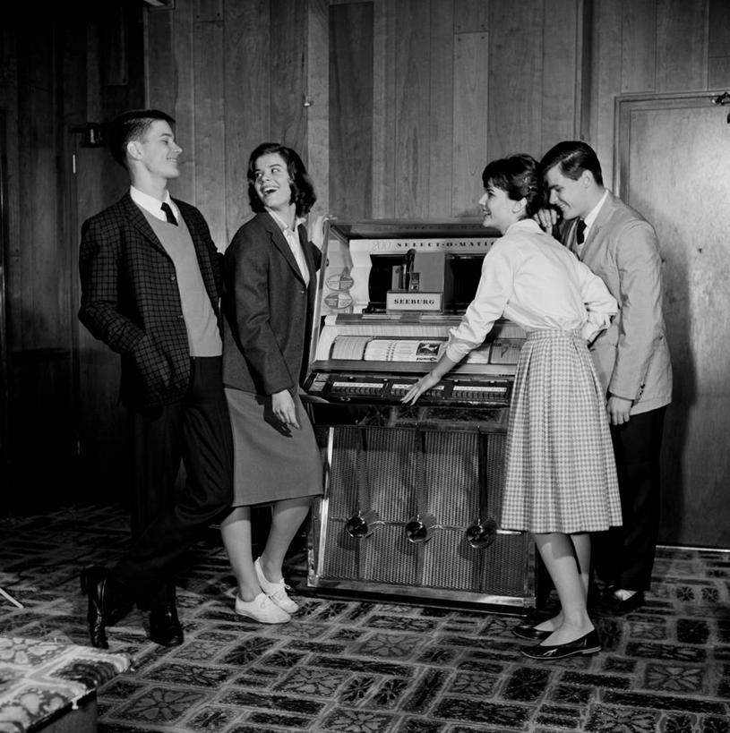 西方人,成年人,四个人,笑,微笑,露齿笑,竖图,方图,黑白,室内,白天,快乐,友谊,幸福,欧洲,美国,欧洲人,表演,音乐,听,自动售货机,乐趣,摄影,高雅,享乐,老虎机,自动点唱机,年轻男性,年轻女性,白种人,年轻人