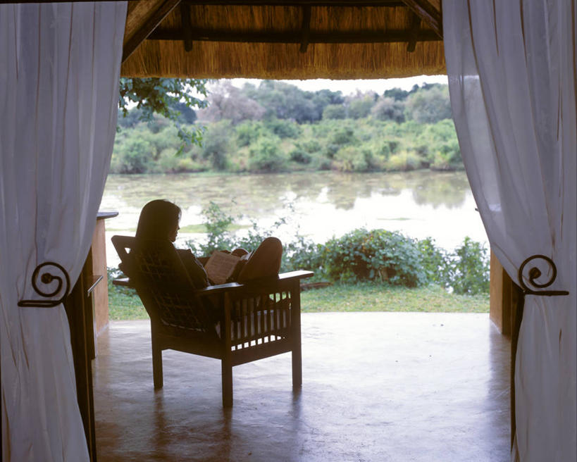 成年人,一个人,坐,横图,室内,留白,满意,河流,卧室,酒店,椅子,非洲,赞比亚,仅一个女性,木制,河岸,看,放松,读书,摄影,享乐,华贵,蜜月,女人,彩图,门廊,南卢安瓜国家公园,独处