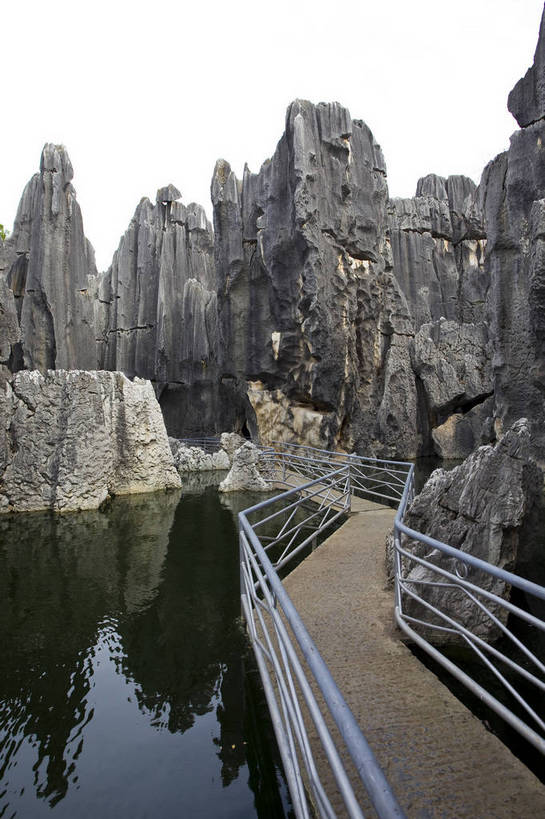 无人,竖图,彩色,室外,白天,旅游,度假,湖,石头,名胜古迹,石林,标志建筑,地标,建筑,昆明,中国,亚洲,遗迹,石子,图片,巨石,古迹,文物,娱乐,建设,古建筑,云南,树木,湖水,享受,休闲,旅游胜地,放松,摄影,文明,中国文化,自然风光,昆明市,古文明,东亚,云南省,中华人民共和国,省会,西南地区,滇,自然遗产,石林县,石林彝族自治县,石块,岩石,旅行,云南石林地质公园,传统文化,浮桥,bj174